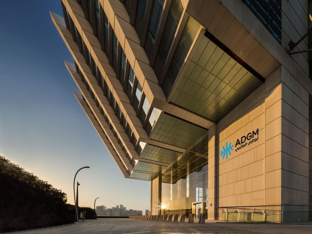 Entrance of the Abu Dhabi Global Market building with ADGM signage at dusk