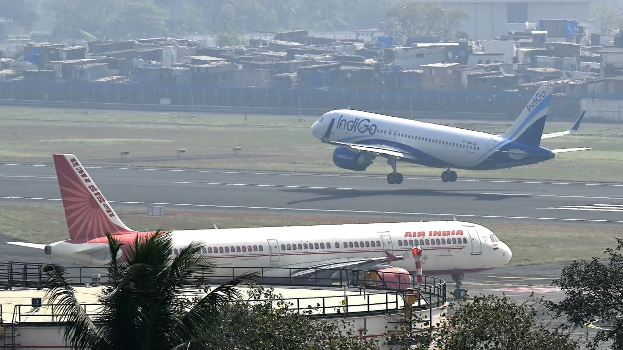 An Air India aircraft taxis as an IndiGo plane takes off at an Indian airport