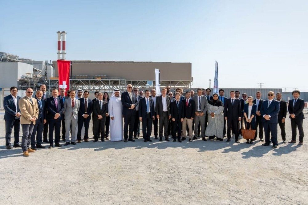 Project partners and guests stand in front of the AlBihouth Waste-to-Energy Facility in Abu Dhabi
