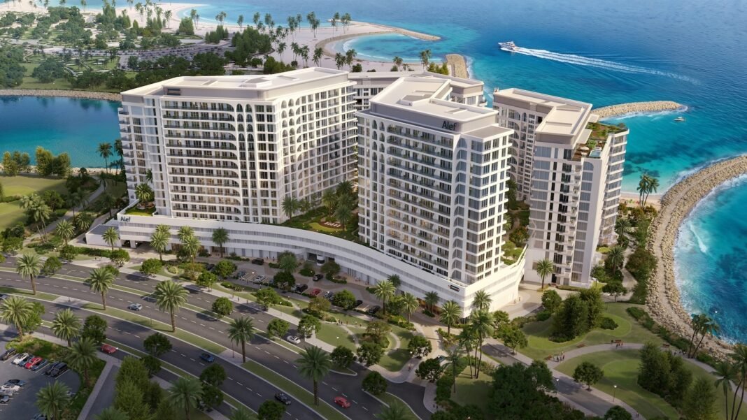 Rendering of five white residential towers on a palm-lined peninsula with a beach, a lagoon and the sea on three sides