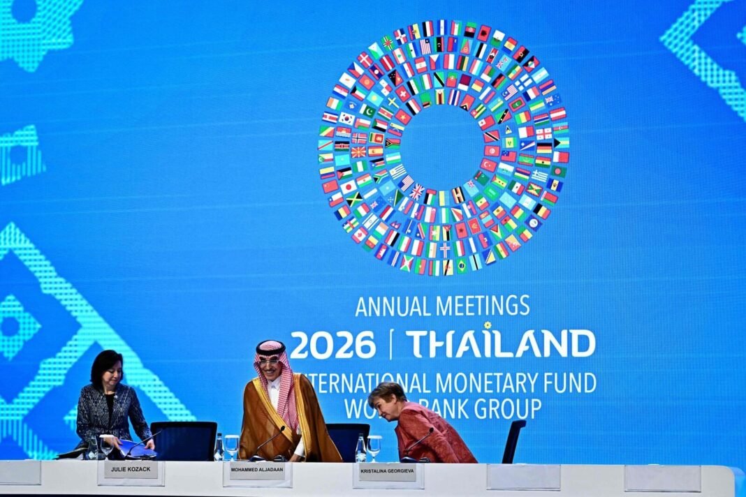 Mohammed Al-Jadaan and Kristalina Georgieva take their seats at a news conference table in front of the IMF and World Bank 2026 Annual Meetings Thailand backdrop
