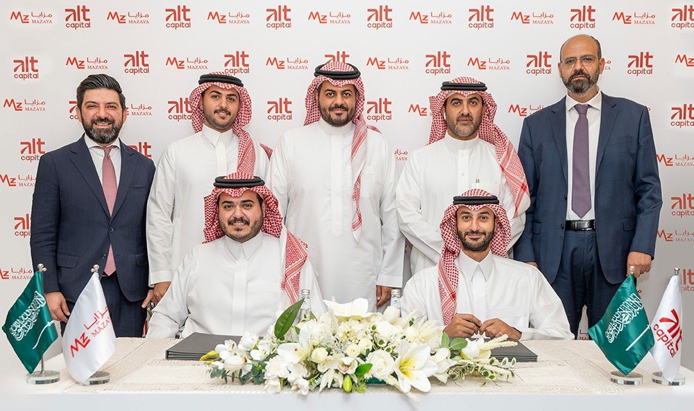 Executives in Saudi dress and suits pose behind a signing table with Saudi flags and Alt Capital and Mazaya branding