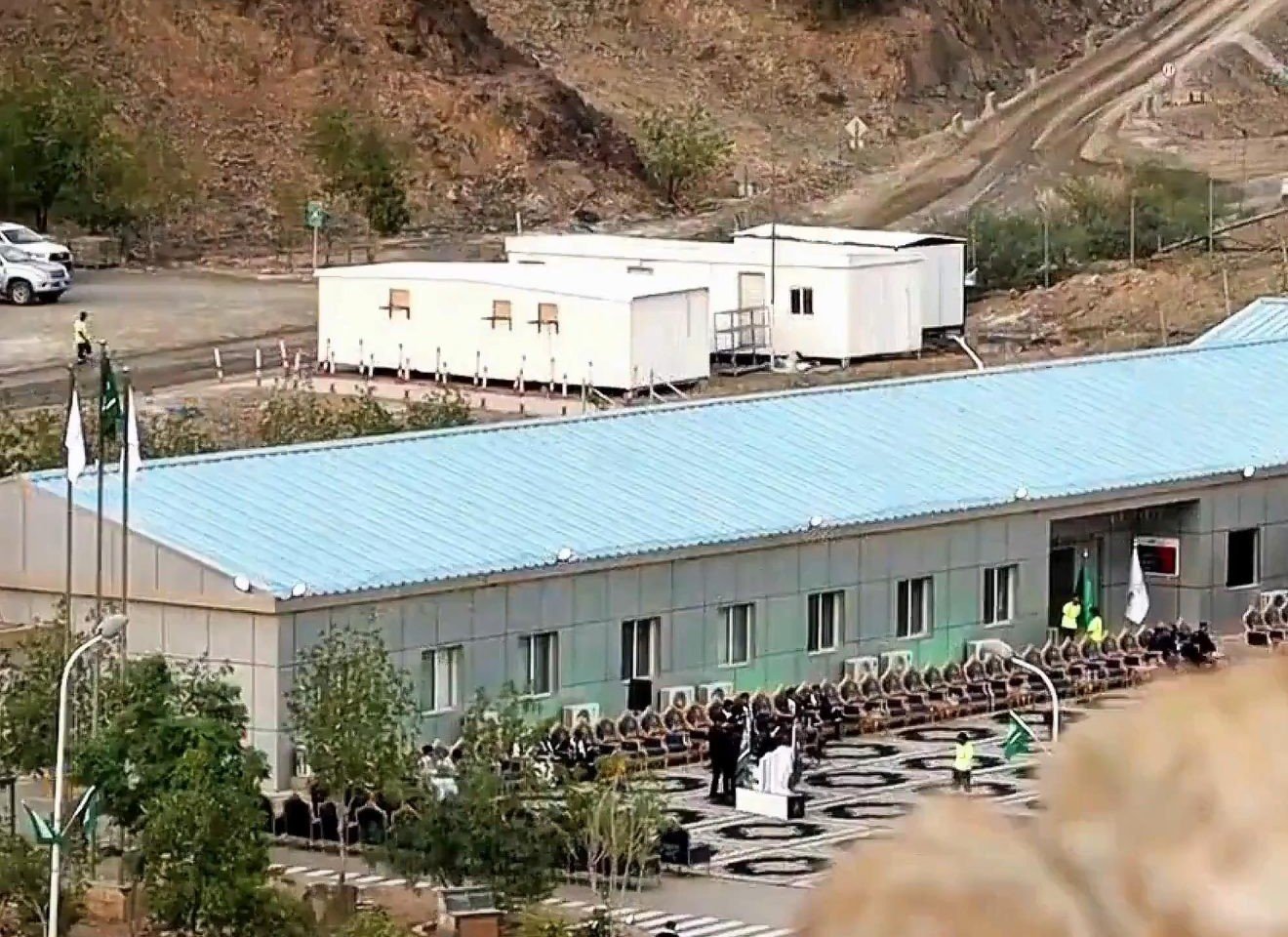 Site buildings and a seated gathering at an Al Masane Al Kobra Mining Company facility in Saudi Arabia