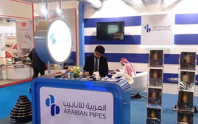 An Arabian Pipes Company exhibition stand with staff seated at a reception desk
