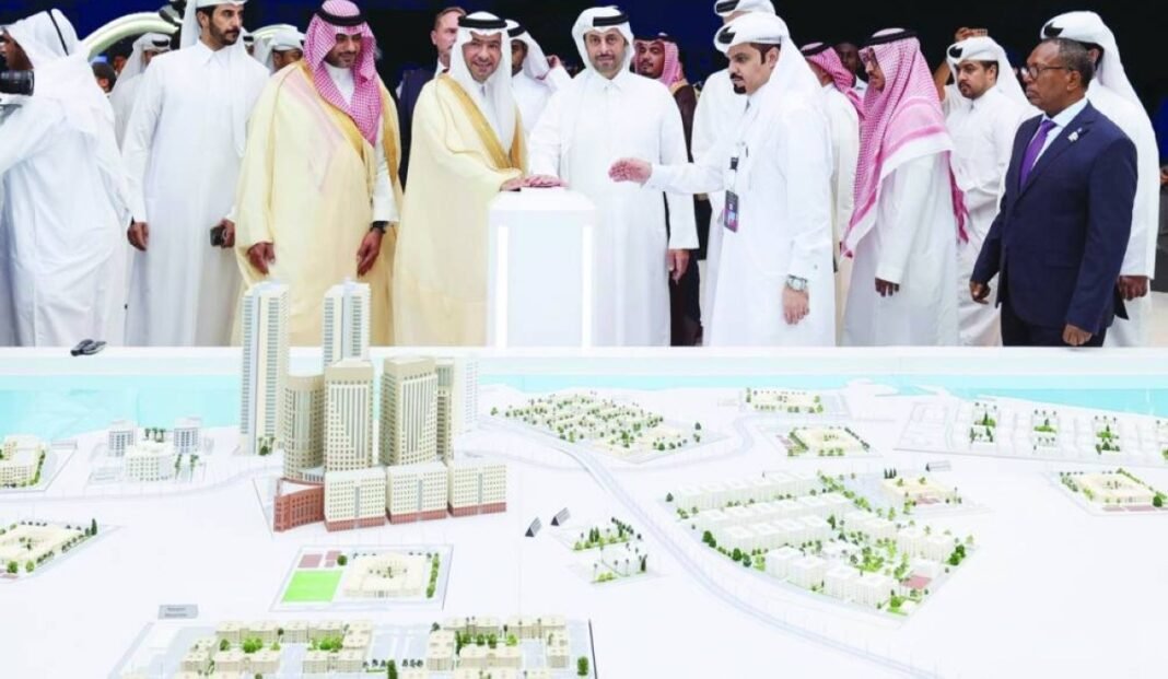 Officials gather around a model of a Barwa Real Estate development during an unveiling ceremony