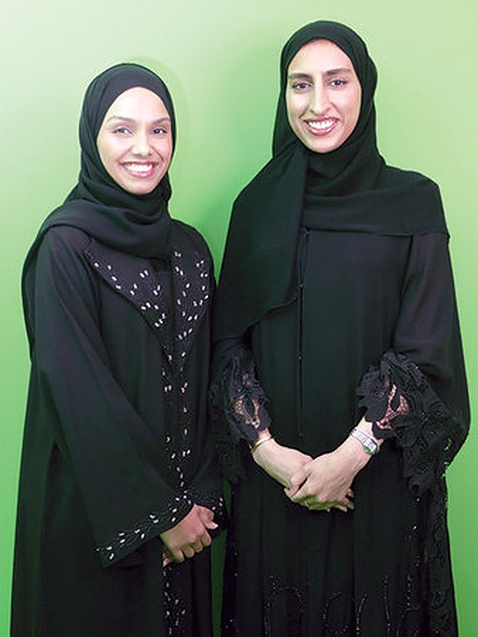 Boom co-founders Mariam Mohammed Almarri and Mariam Khalifa Alnuaimi stand together against a green backdrop