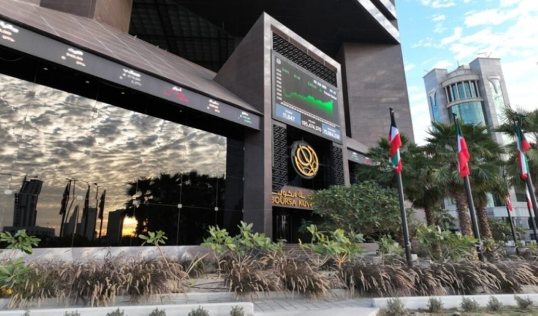The Boursa Kuwait building with a large screen above its entrance and flags along the street outside