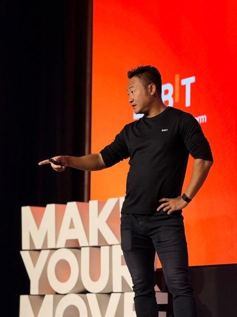 Bybit chief executive Ben Zhou gesturing on stage in front of a red Bybit screen