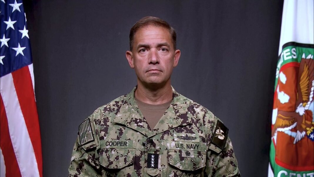 US Navy Admiral Brad Cooper, commander of US Central Command, standing between a US flag and a CENTCOM flag