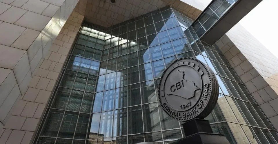 Glass facade of the Central Bank of Iraq headquarters in Baghdad with the bank's circular emblem in front