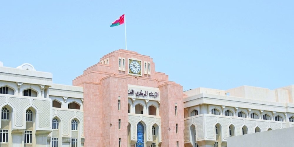 Central Bank of Oman headquarters building with the Omani flag on its clock tower