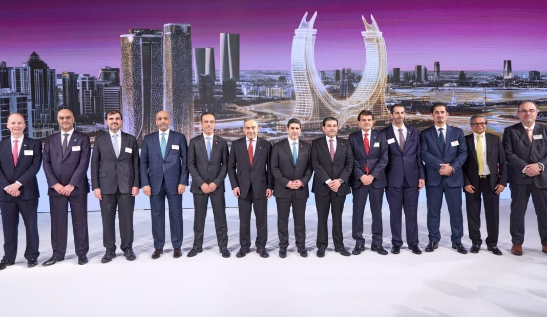 A line of Commercial Bank executives and board members in suits standing in front of a screen showing the Doha skyline