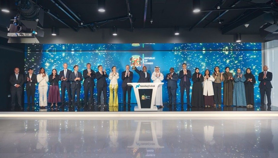 Officials applaud on a stage at Nasdaq Dubai in front of a screen showing the Republic of Congo's coat of arms