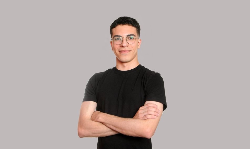 Issa Nassar, founder of Databuddy, standing with arms crossed in front of a gray backdrop