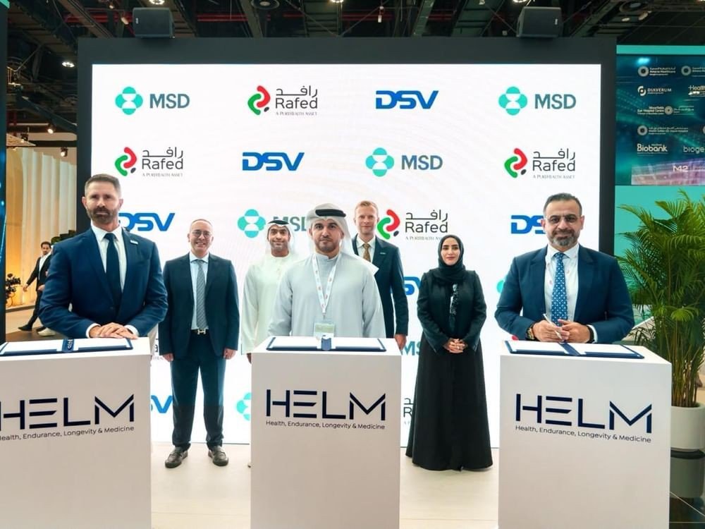 MSD, DSV and RAFED executives standing at signing desks in front of a screen showing the companies' logos