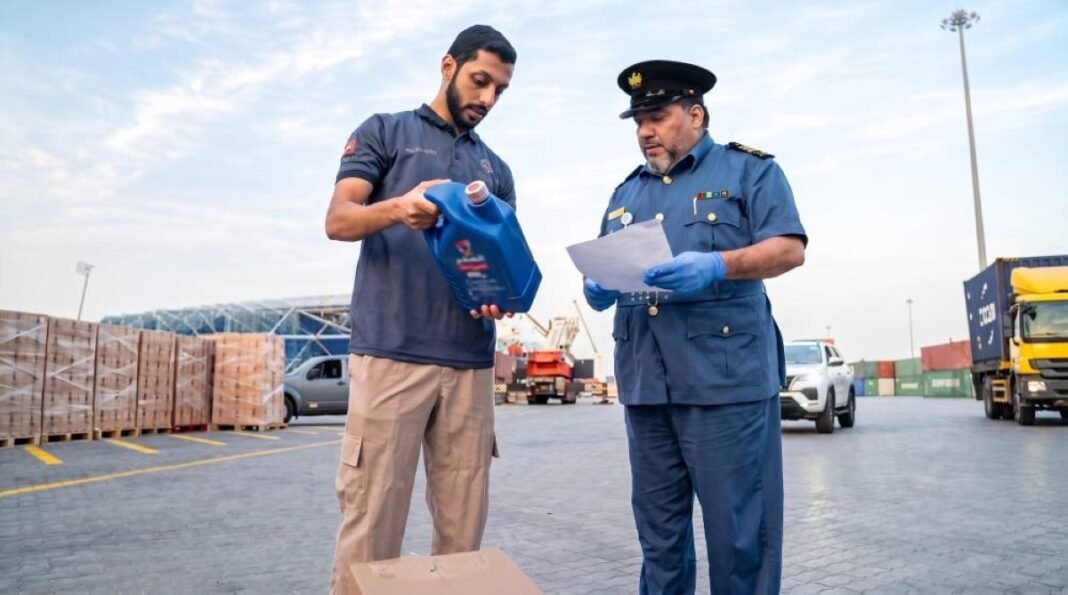 A Dubai Customs officer reviews documents while a trader holds up a product container at a cargo yard in Dubai
