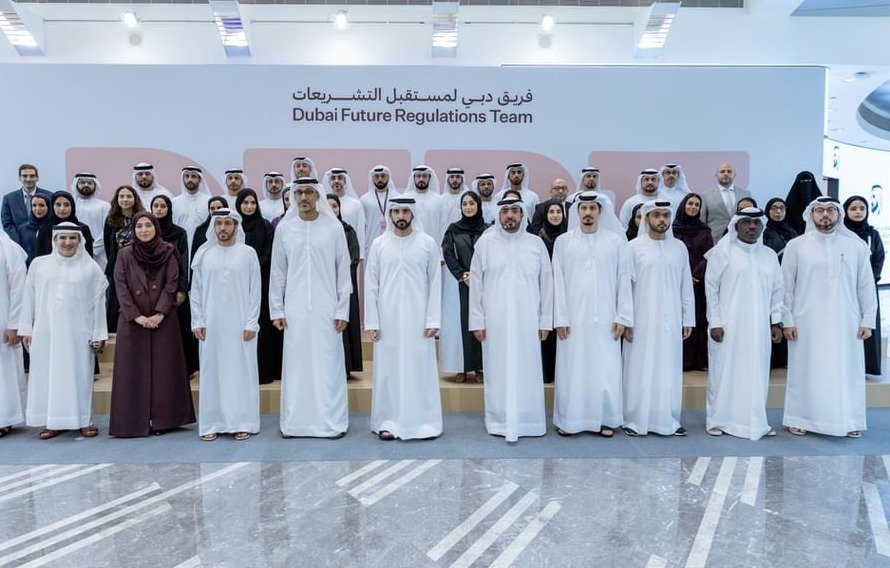 Sheikh Hamdan bin Mohammed stands with members of the Dubai Future Regulations Team in front of a sign bearing the team's name