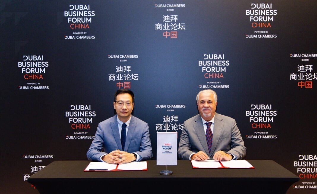 Tawhid Abdullah of the Dubai Jewellery Group and Ye Yongguang of the Gold Association of Guangdong Province seated at a signing table at the Dubai Business Forum China