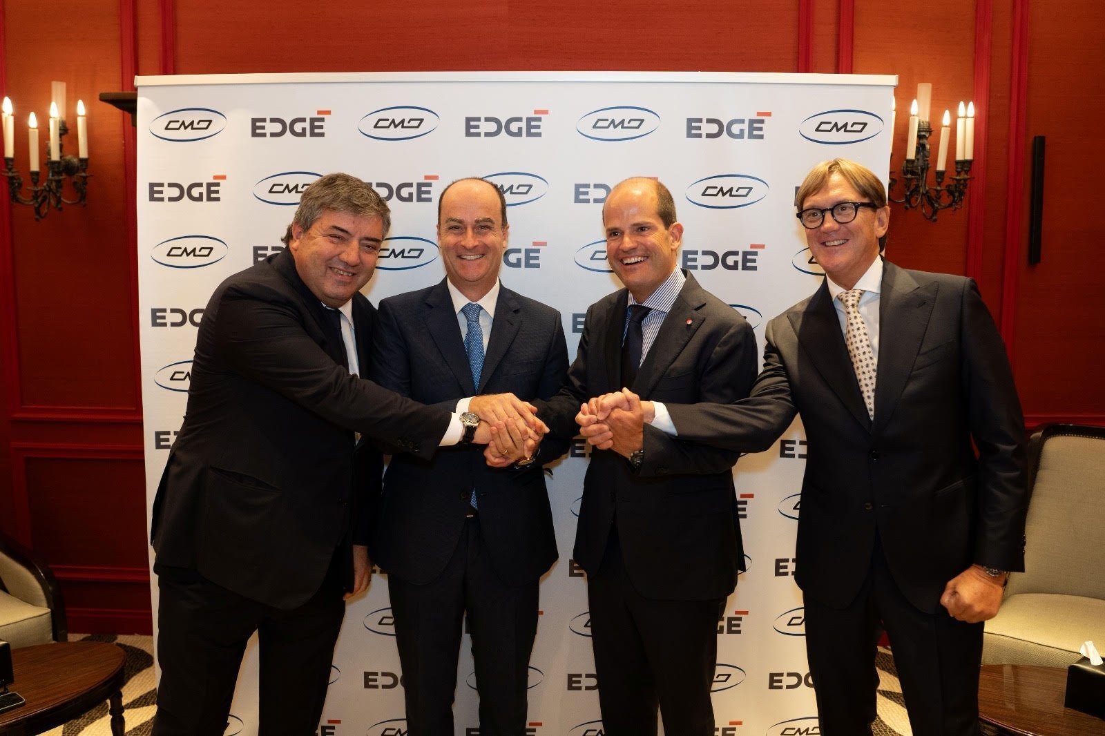 Executives from EDGE and CMD shake hands at a signing ceremony
