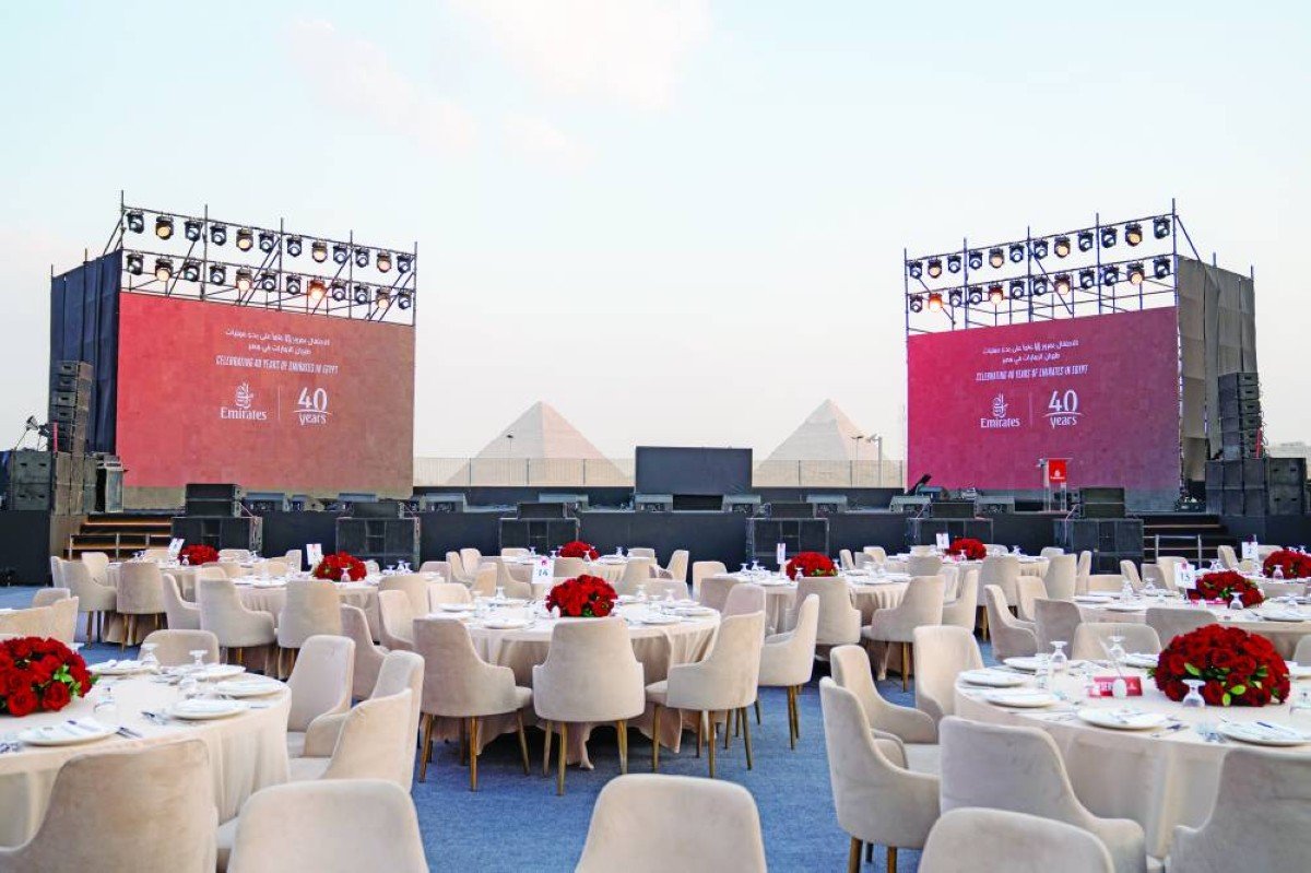 Dinner tables and stage screens reading Celebrating 40 years of Emirates in Egypt, with the Giza pyramids in the background