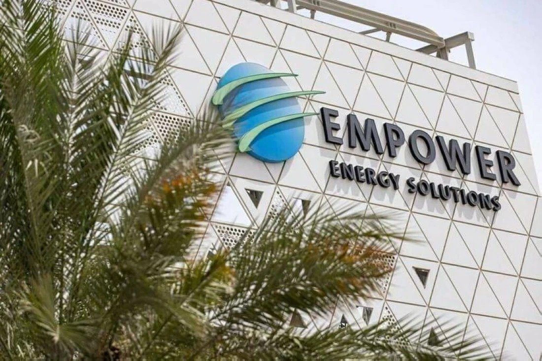Empower Energy Solutions logo on the white patterned facade of a company building in Dubai, behind palm fronds
