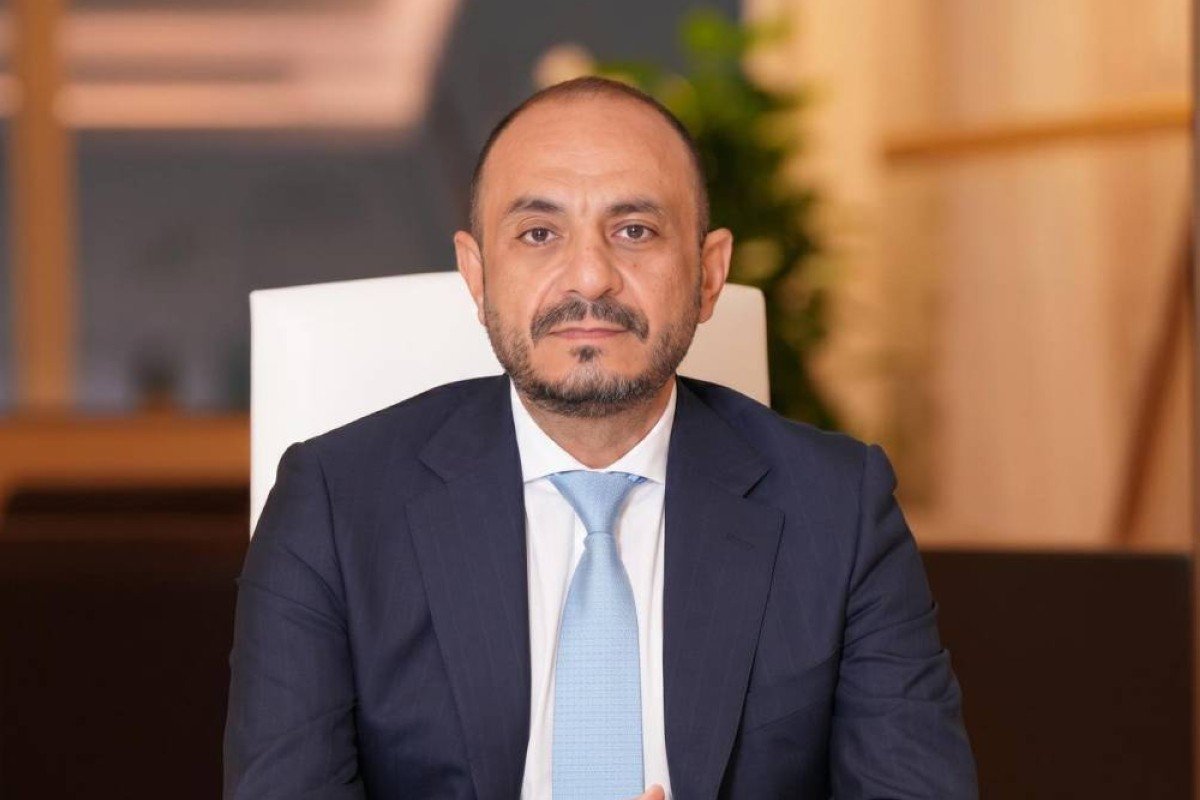 Estithmar Holding chief executive Basel Shaddad seated at a desk in a dark suit and light blue tie