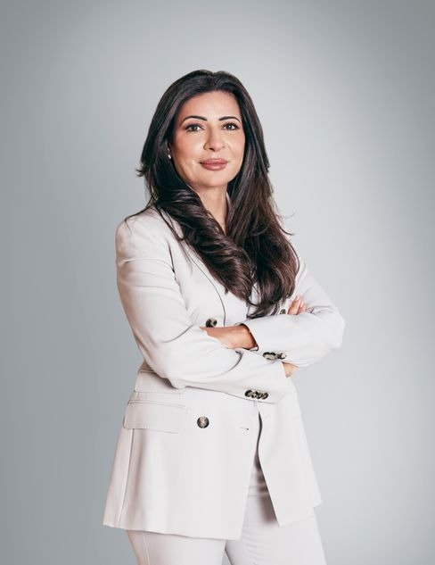 Hana Al Rostamani, group chief executive officer of First Abu Dhabi Bank, in a white suit with arms folded