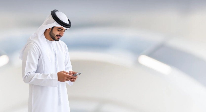 A man using a smartphone, image released with the announcement of TAMM Global in Abu Dhabi