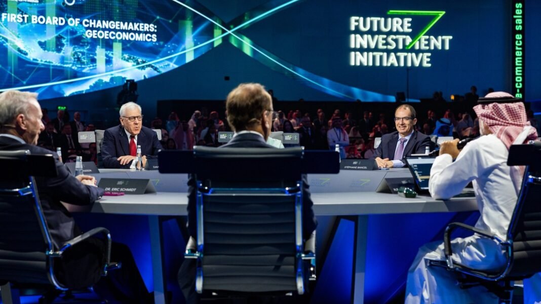 Panelists seated at a round table on stage during a Future Investment Initiative session