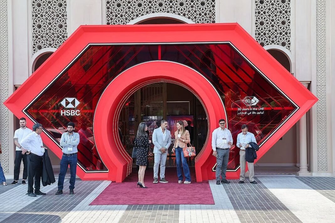 Attendees stand at a red arched HSBC entrance marking 80 years in the UAE at the bank's wealth summit in Dubai