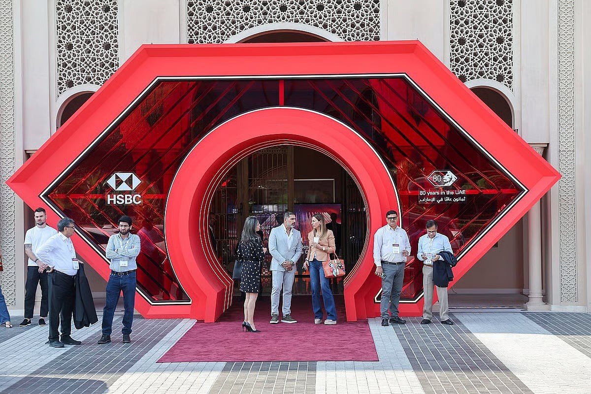 Attendees stand at a red arched HSBC entrance marking 80 years in the UAE at the bank's wealth summit in Dubai