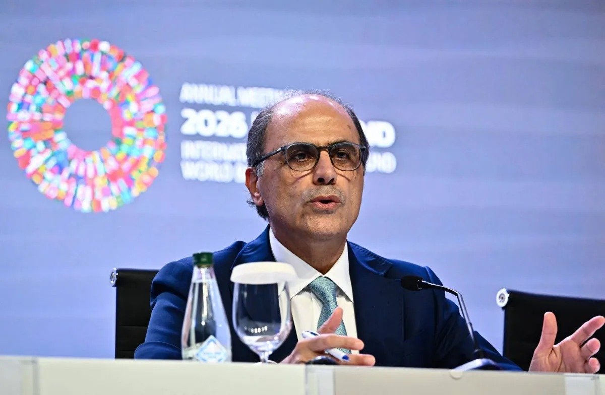 Jihad Azour speaks at a press briefing table in front of an IMF and World Bank annual meetings backdrop
