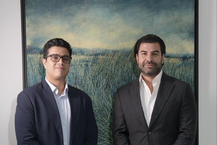 JustAd founder and chief executive Ahmed Elsayed and angel investor Imad Jomaa stand in front of a landscape painting