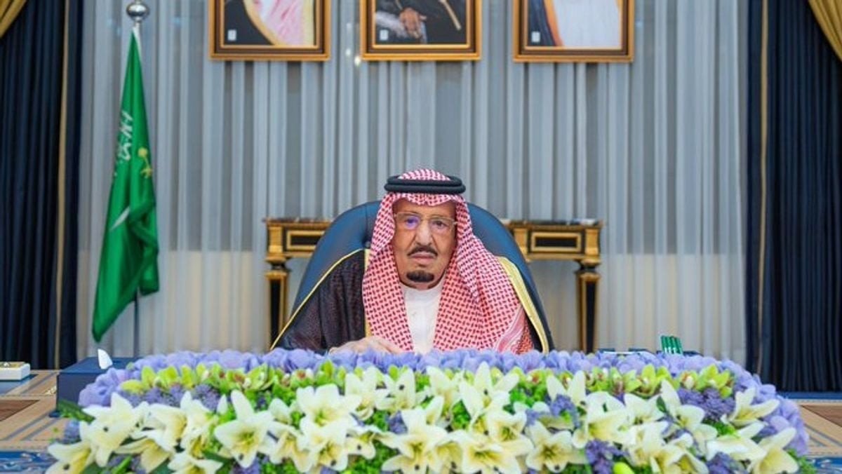 King Salman seated at a desk decorated with flowers during a Cabinet session in Riyadh