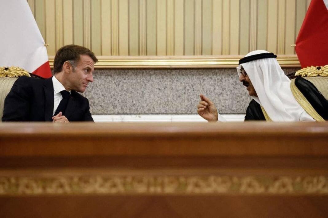 French President Emmanuel Macron and Kuwait's Amir Sheikh Meshal Al-Ahmad Al-Jaber Al-Sabah talk while seated before French and Kuwaiti flags