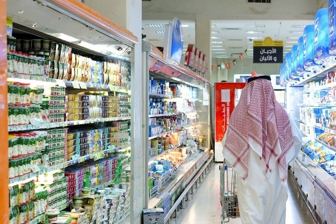 A shopper pushes a trolley through a supermarket aisle in Kuwait