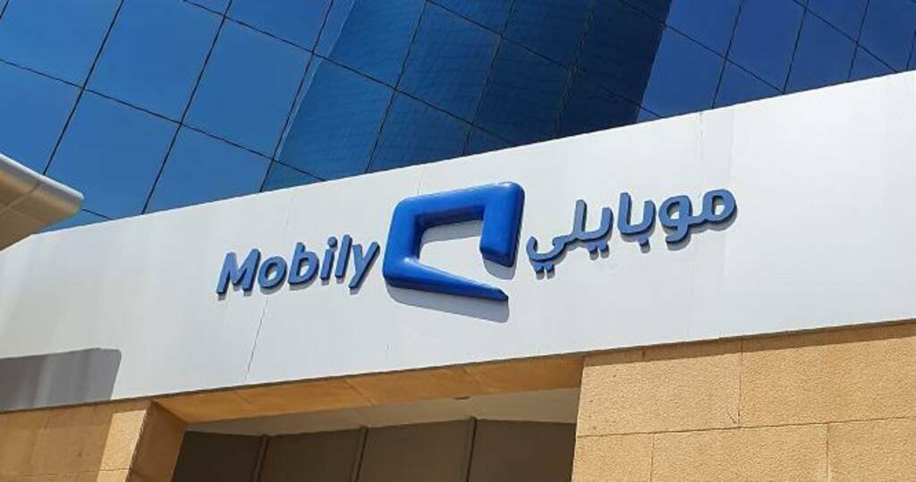 Blue Mobily logo and Arabic and English name on a white facade beneath a blue glass building