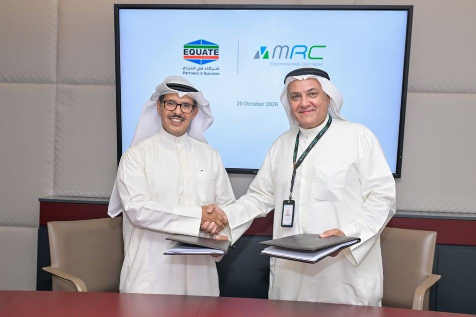 Two executives in white dishdashas shaking hands and holding signed folders in front of a screen showing EQUATE and MRC logos