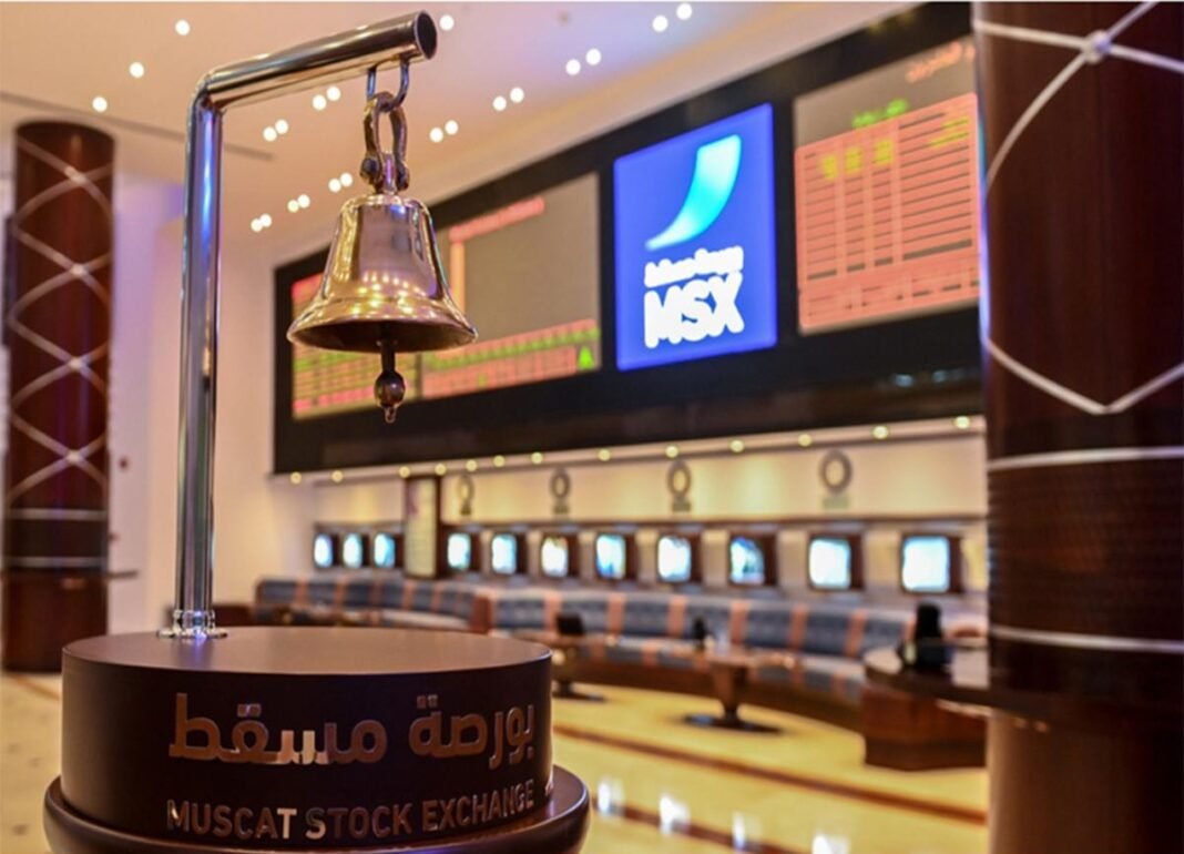 The opening bell stands in front of trading screens in the Muscat Stock Exchange trading hall