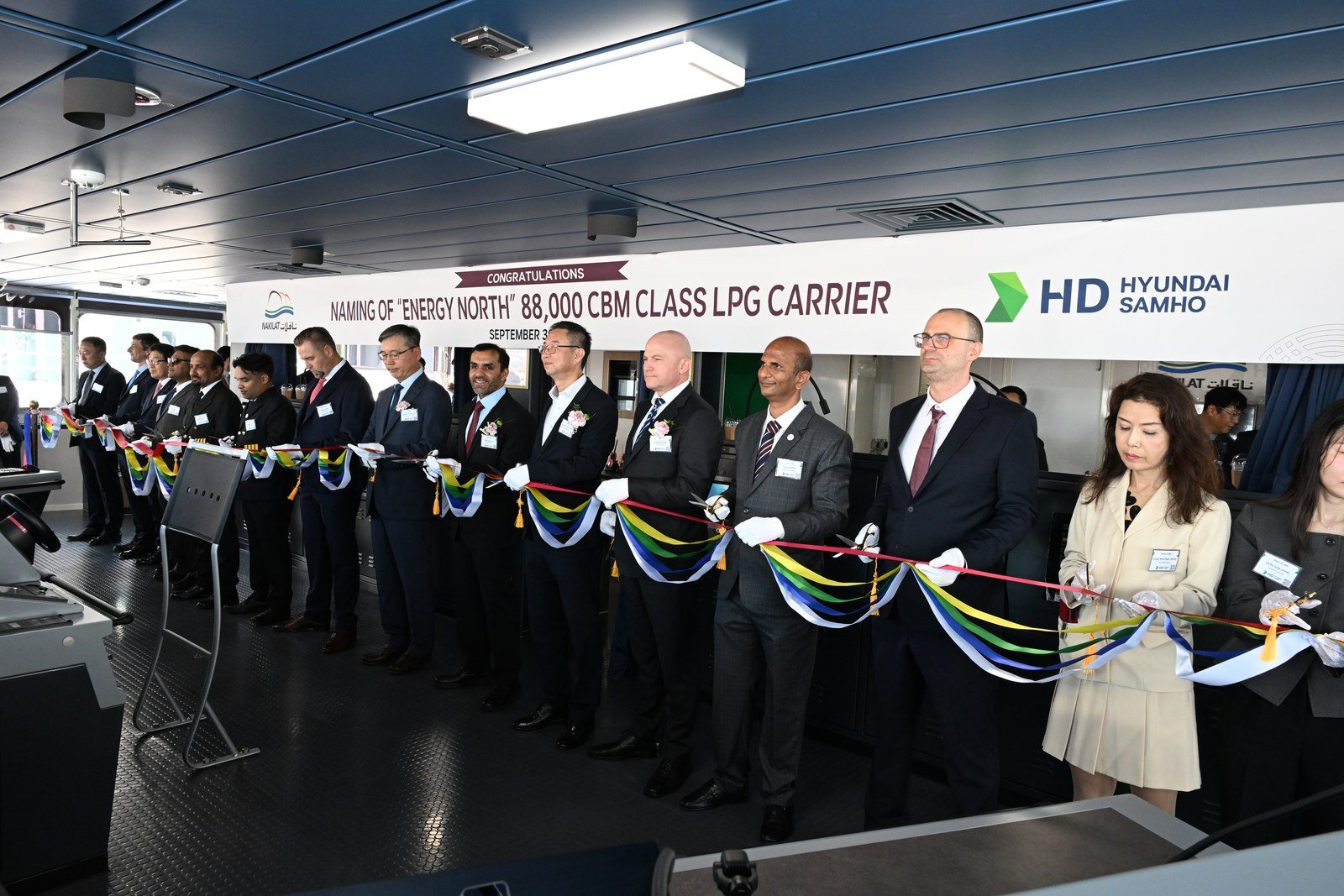 Officials in suits cut colored ribbons on a ship's bridge under a banner reading Naming of Energy North 88,000 CBM Class LPG Carrier