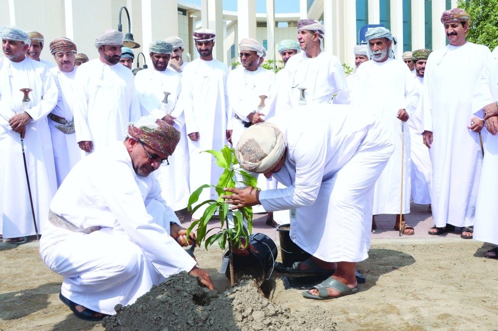Omani officials plant a seedling at an Agriculture Day ceremony at Sohar University