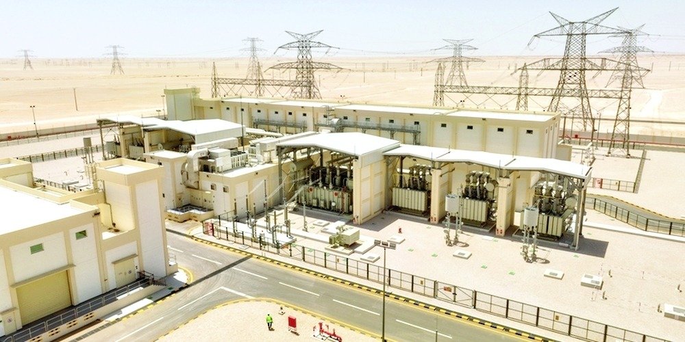 Aerial view of an electricity substation with transformers and transmission towers in the desert in Oman