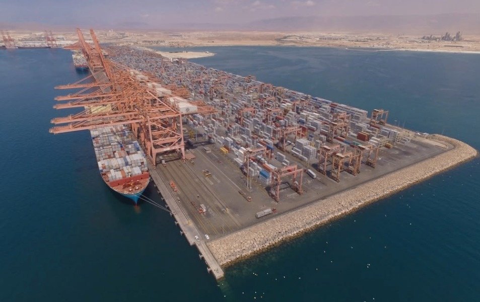 Container cranes and a cargo ship at a port terminal in Oman