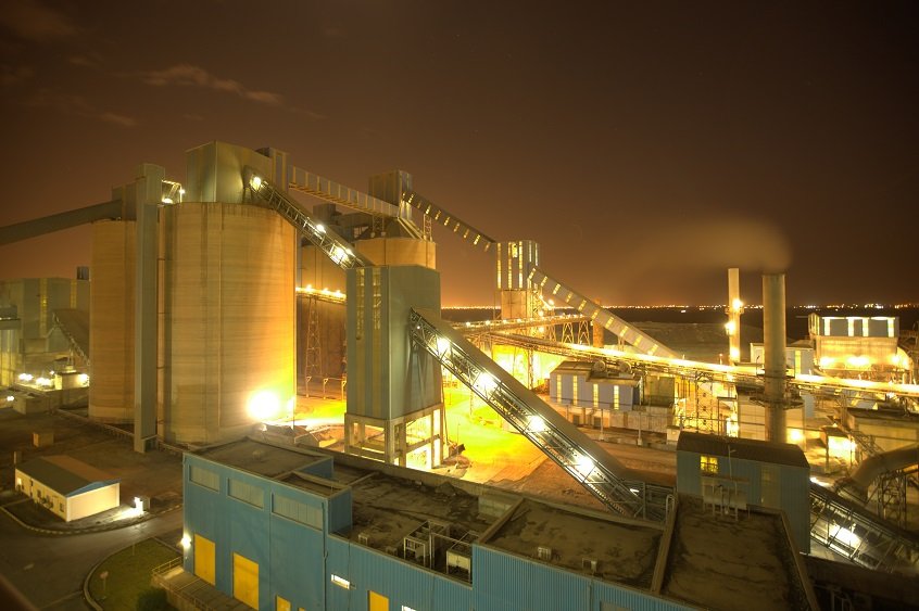 Qassim Cement Company's plant with silos and conveyors lit up at night