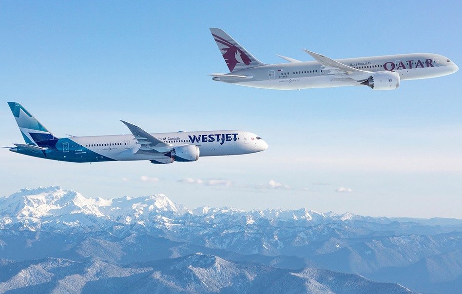 A Qatar Airways Boeing 787 and a WestJet Boeing 787 in flight over snow-covered mountains