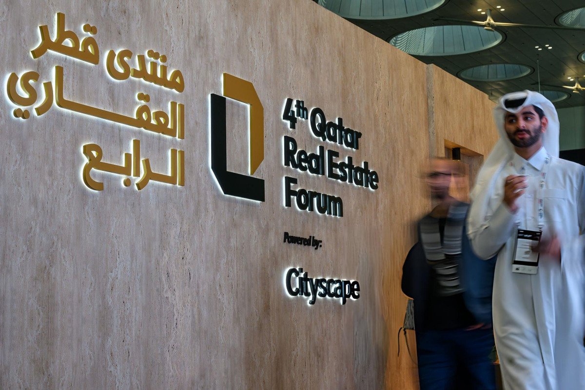 Visitors walk past the entrance sign of the 4th Qatar Real Estate Forum, powered by Cityscape, in Doha