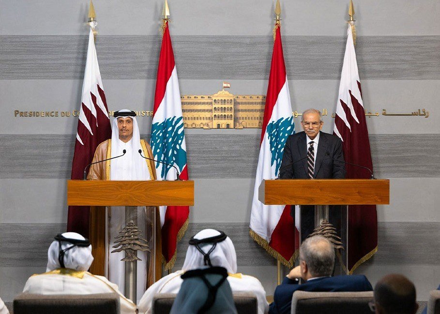 Qatari and Lebanese prime ministers speak at wooden podiums between Qatari and Lebanese flags in Beirut