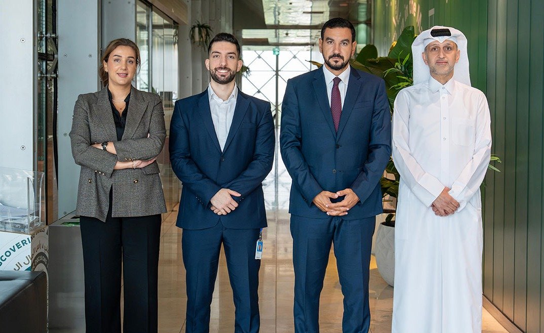 Four officials from Qatar Science and Technology Park and Microsoft pose in an office corridor in Doha
