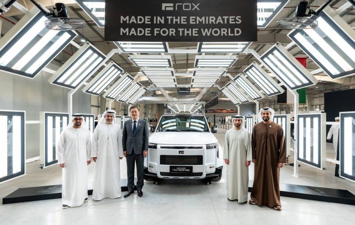 Officials stand beside a white ROX SUV under a Made in the Emirates, Made for the World sign at the ROX factory in Abu Dhabi