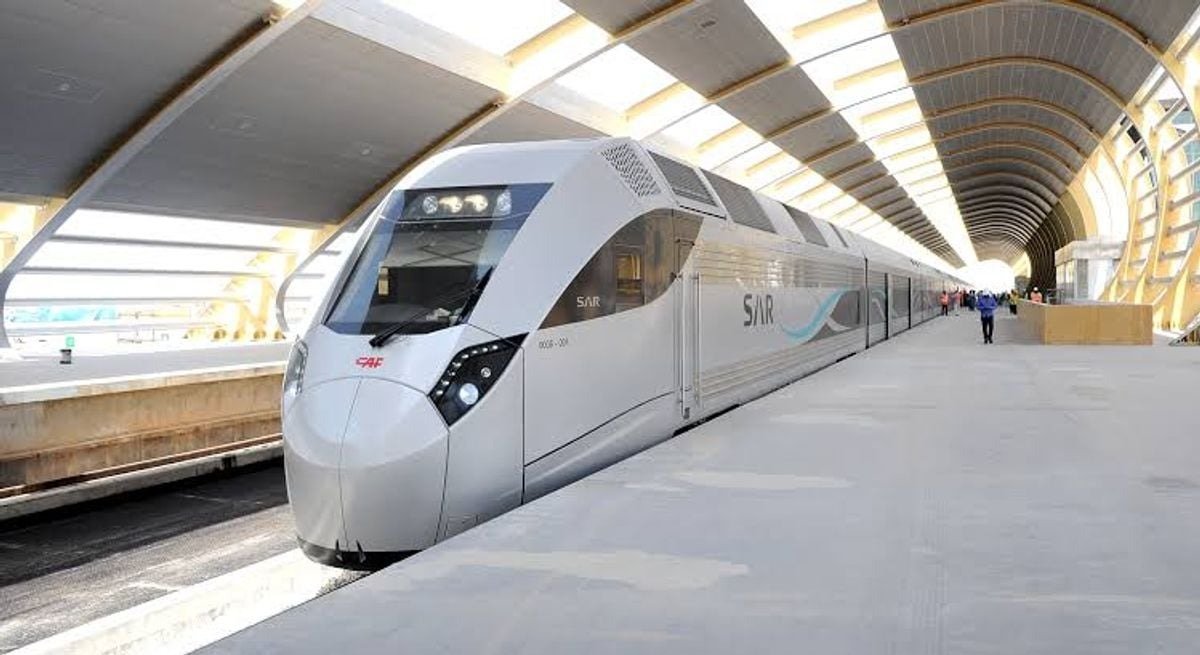 A Saudi Arabia Railways passenger train stands at a covered station platform